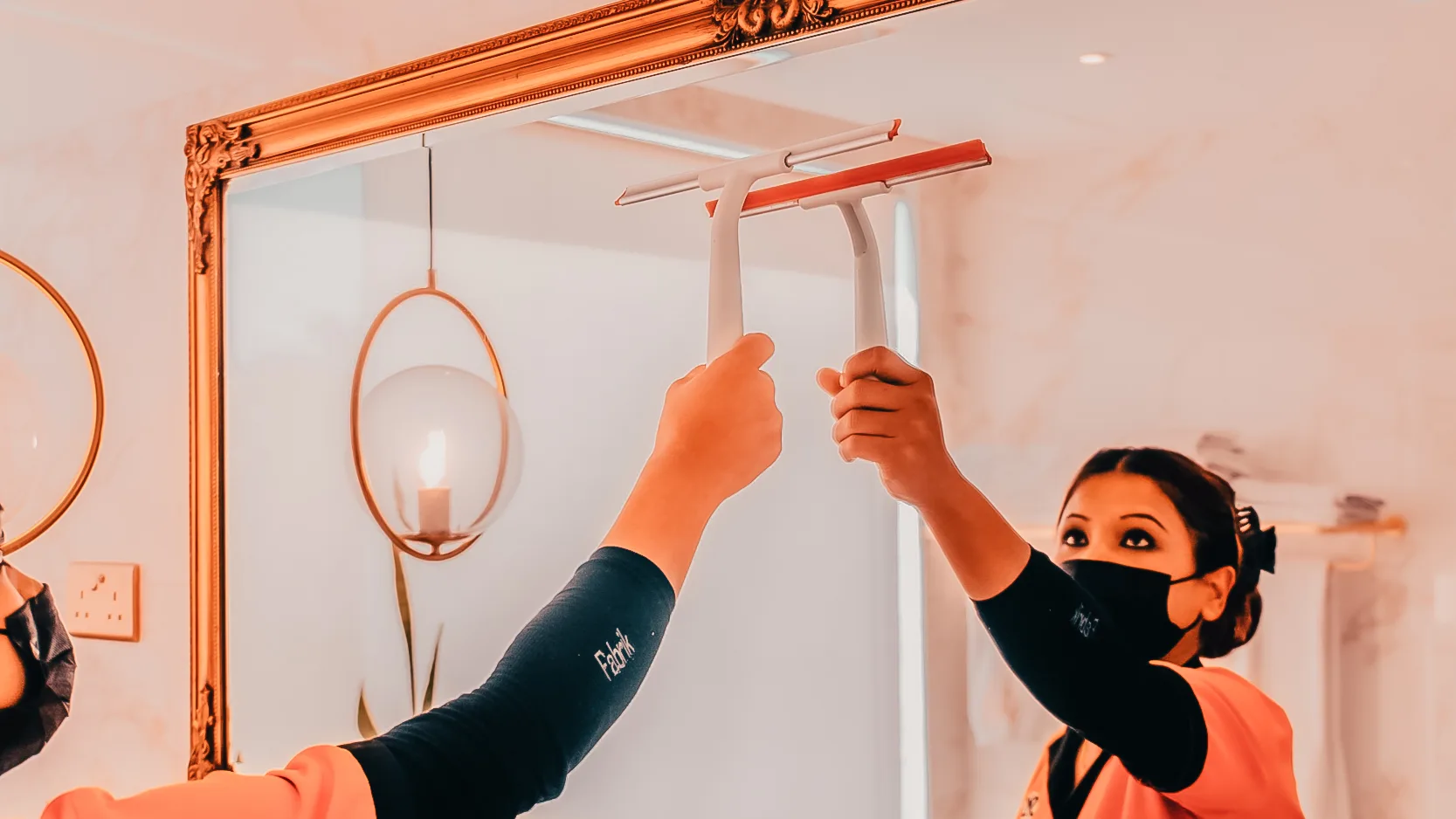 SMS maid cleaning a mirror with squeegee